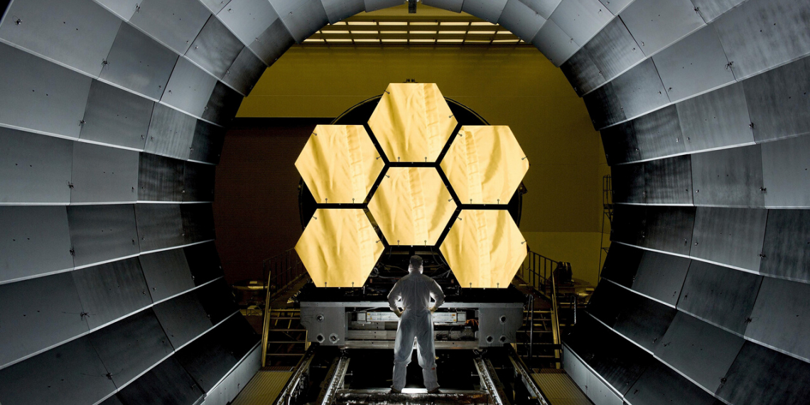 Photo of man in front of large optics.