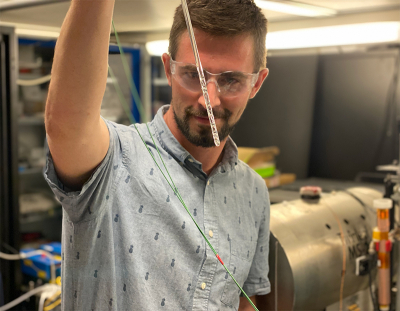 Photo of Danila Barskiy holding an NMR tube