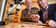 Photo of Kenneth Sheedy and Gil Davis examining ancient coins.