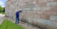 The author examining a church stone wall