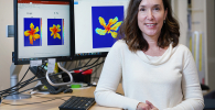 Photo of Lori Hoagland with computer screens showing hyperspectral images of plants in the bakground.